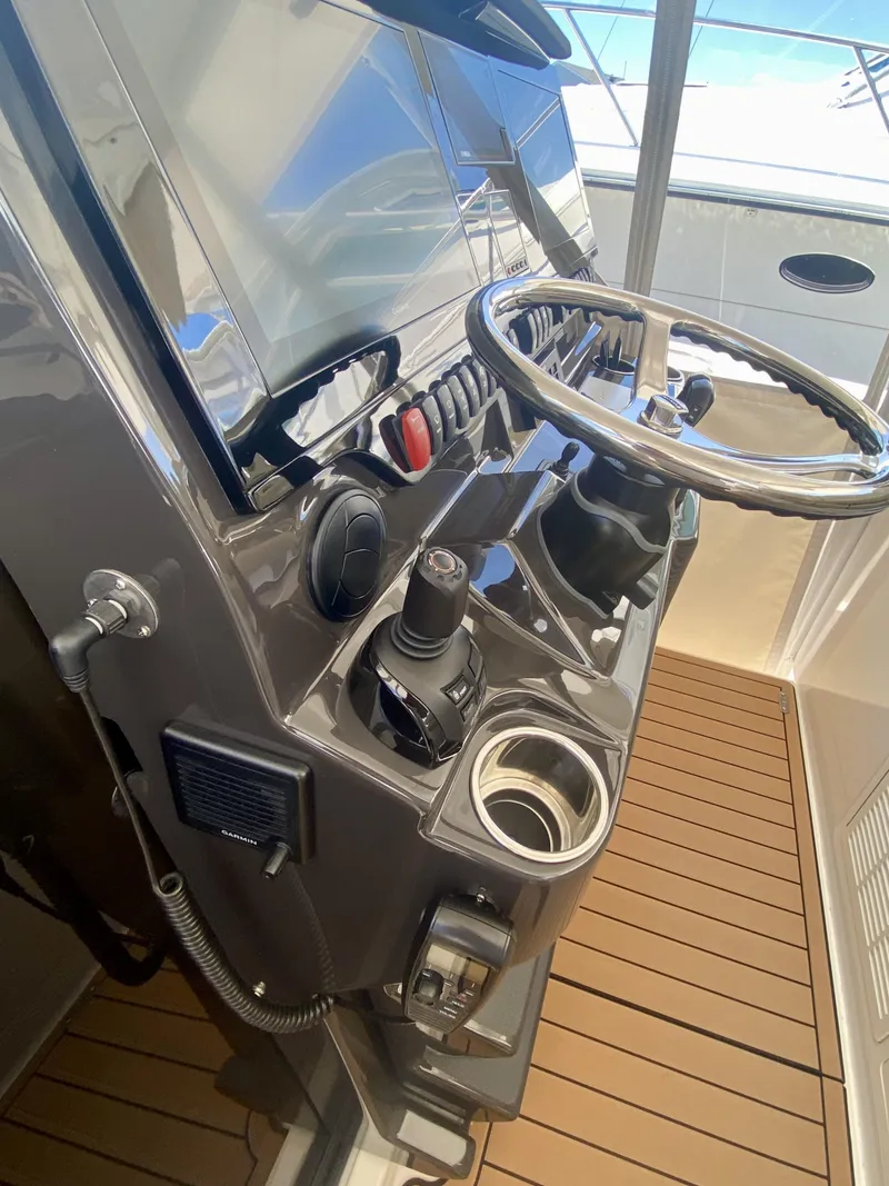 Slide: The Image of 2019 Pursuit S 408 Sport boat helm with steering wheel and controls. - 20