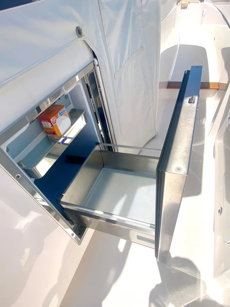 Slide: The Image of 2019 Pursuit S 408 Sport boat with open stainless steel storage compartment. - 28