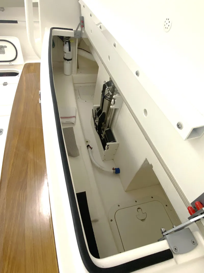 Slide: The Image of 2019 Pursuit S 408 Sport boat storage compartment with white interior and wooden accents. - 31