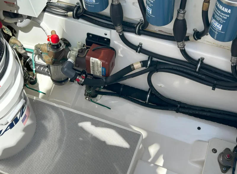 Slide: The Image of Engine compartment of a 2019 Pursuit S 408 Sport boat, showing hoses and components. - 48