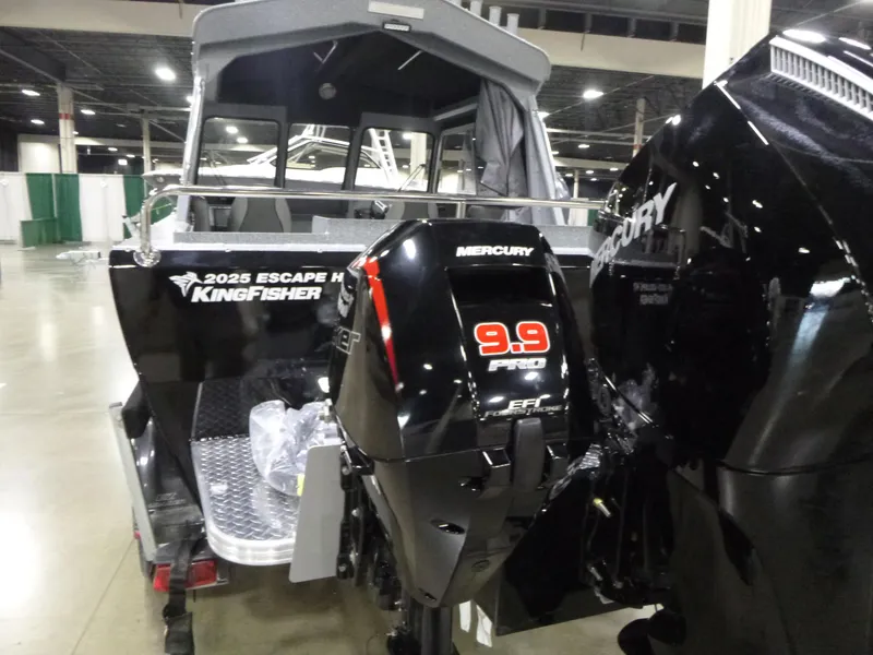 Slide: The Image of 2025 KingFisher Escape HT boat with Mercury 9.9 Pro outboard motor displayed indoors. - 23