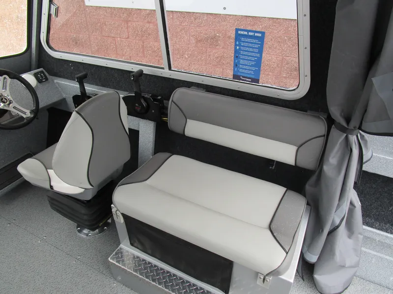 Slide: The Image of Interior of 2025 KingFisher Escape HT boat with gray seating and steering wheel. - 36