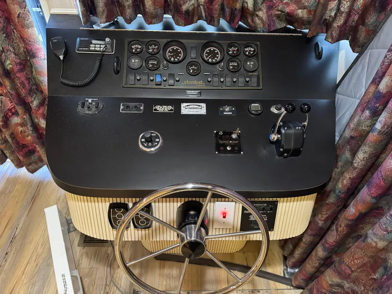 Slide: The Image of Control panel of a 1996 Stardust Cruisers 72x16 houseboat with steering wheel and gauges. - 12