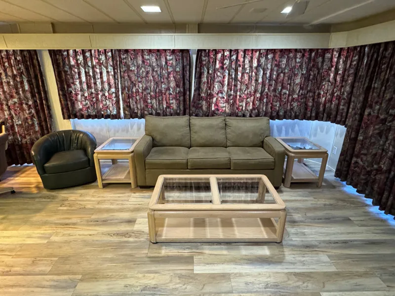 Slide: The Image of Interior of 1996 Stardust Cruisers houseboat with sofa, armchair, and floral curtains. - 16