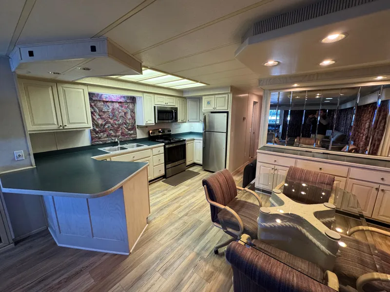 Slide: The Image of Interior of 1996 Stardust Cruisers 72x16 houseboat with modern kitchen and dining area. - 18