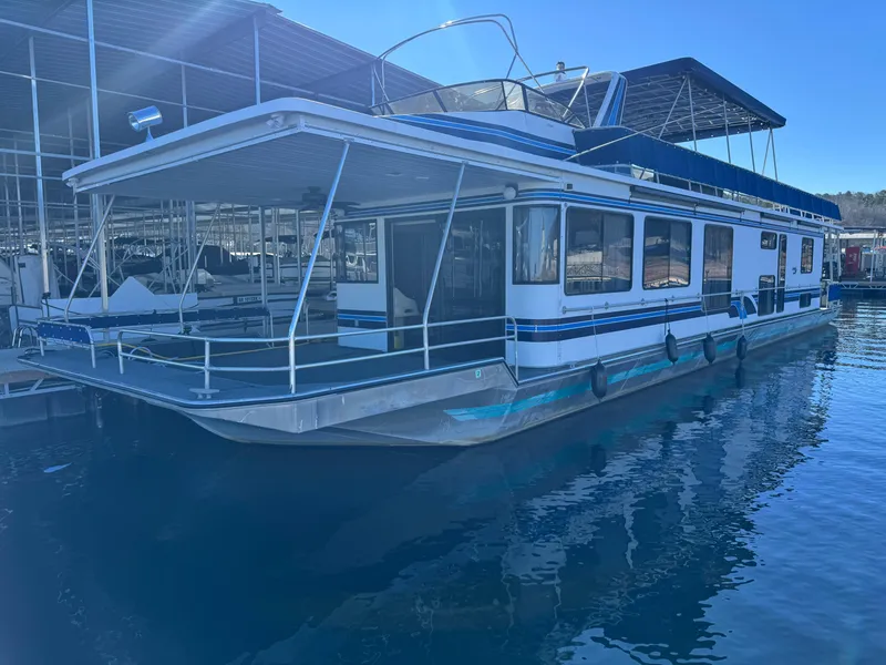 Slide: The Image of 1996 Stardust Cruisers 72x16 houseboat docked in marina, featuring spacious deck and modern design. - 2