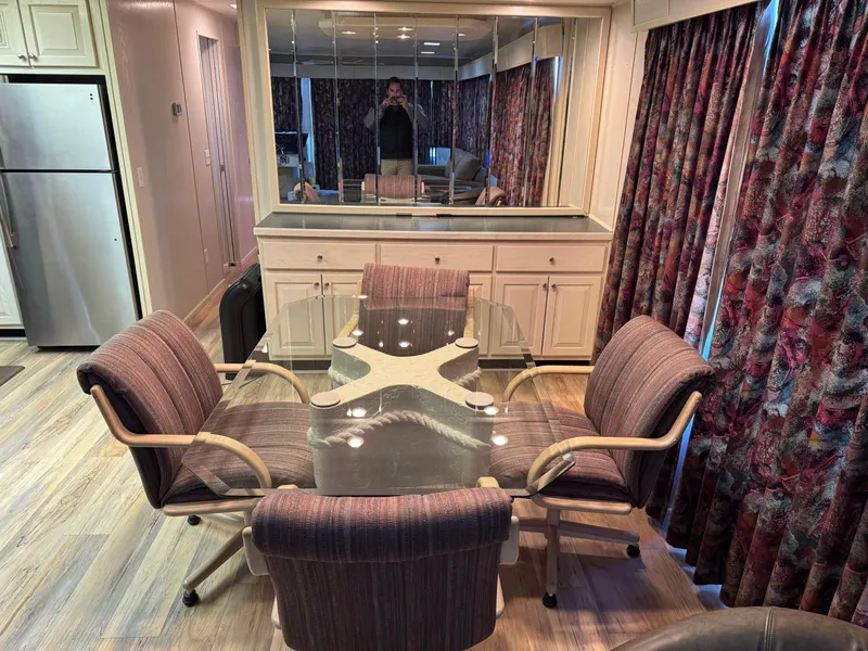 Slide: The Image of Dining area in a 1996 Stardust Cruisers 72x16 houseboat with glass table and upholstered chairs. - 21