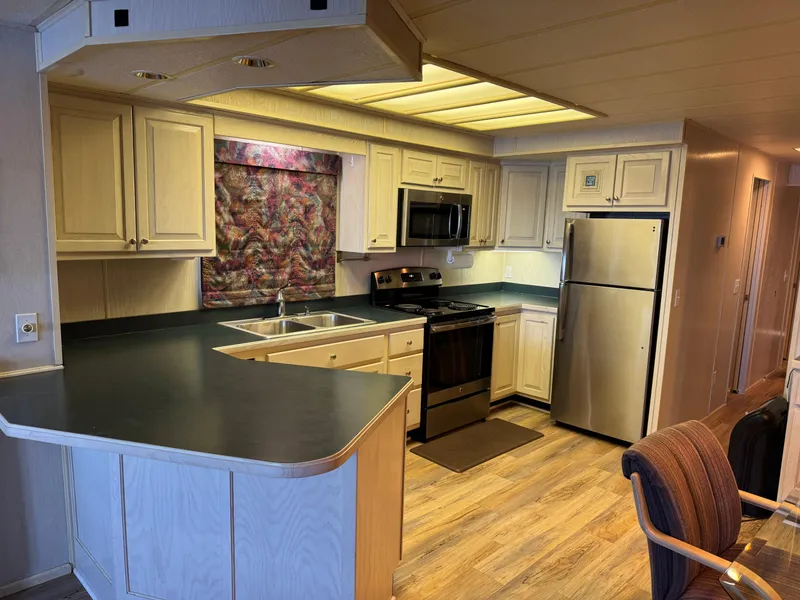 Slide: The Image of Modern kitchen in a 1996 Stardust Cruisers 72x16 houseboat with stainless steel appliances. - 23