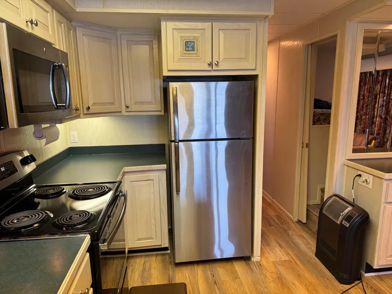 Slide: The Image of 1996 Stardust Cruisers houseboat kitchen with stainless steel appliances and wood flooring. - 24