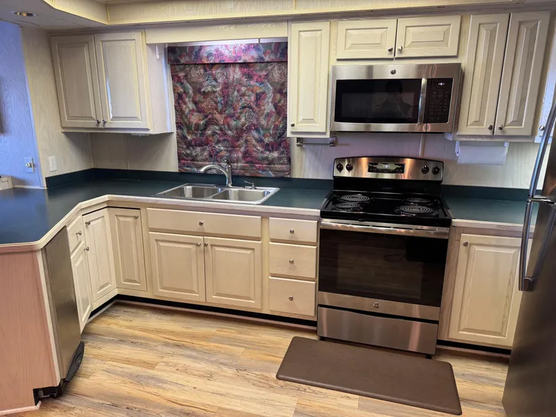 Slide: The Image of Modern kitchen in a 1996 Stardust Cruisers 72x16 houseboat with stainless steel appliances. - 25