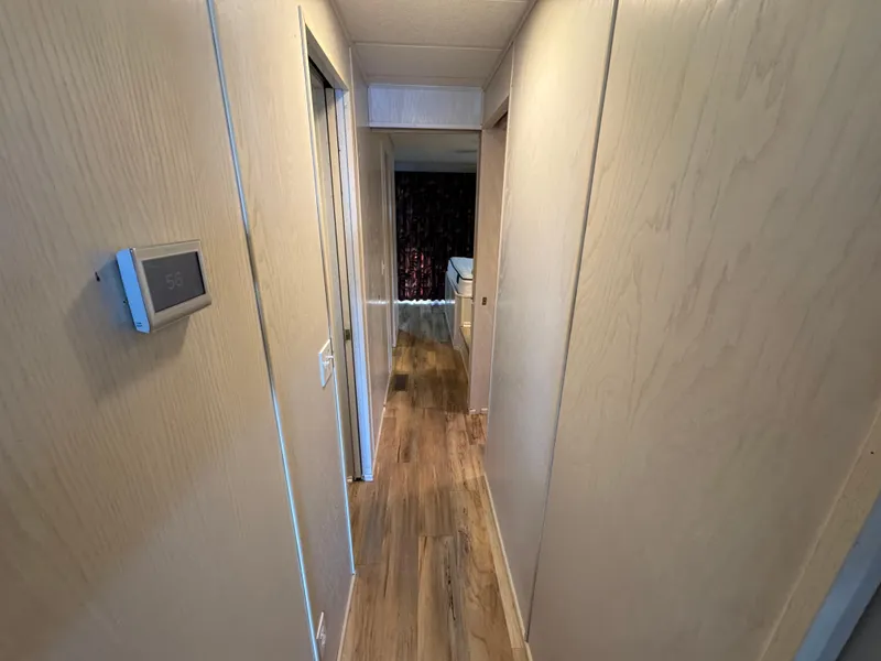 Slide: The Image of Narrow hallway inside 1996 Stardust Cruisers 72x16 houseboat with wood paneling and flooring. - 26