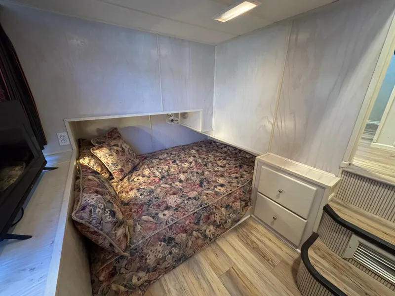 Slide: The Image of Cozy bedroom in 1996 Stardust Cruisers 72x16 houseboat with floral bedding and wooden flooring. - 32