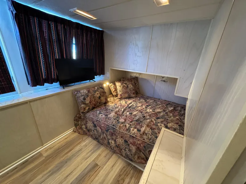 Slide: The Image of Cozy bedroom in 1996 Stardust Cruisers 72x16 houseboat with floral bedding and TV. - 33