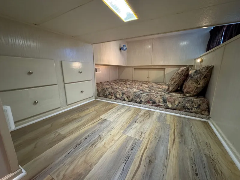 Slide: The Image of Cozy bedroom in 1996 Stardust Cruisers 72x16 houseboat with wood flooring and built-in storage. - 34