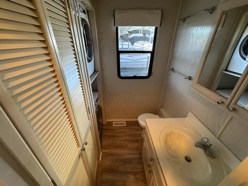 Slide: The Image of Interior of 1996 Stardust Cruisers houseboat bathroom with sink, toilet, and window. - 38