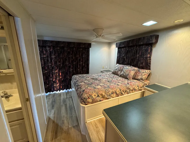 Slide: The Image of Cozy bedroom in 1996 Stardust Cruisers 72x16 houseboat with floral bedding and wood flooring. - 40