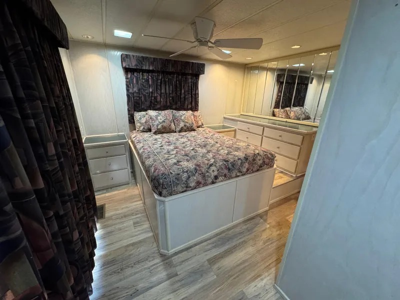 Slide: The Image of Cozy bedroom in 1996 Stardust Cruisers 72x16 houseboat with floral bedding and mirrored dresser. - 41