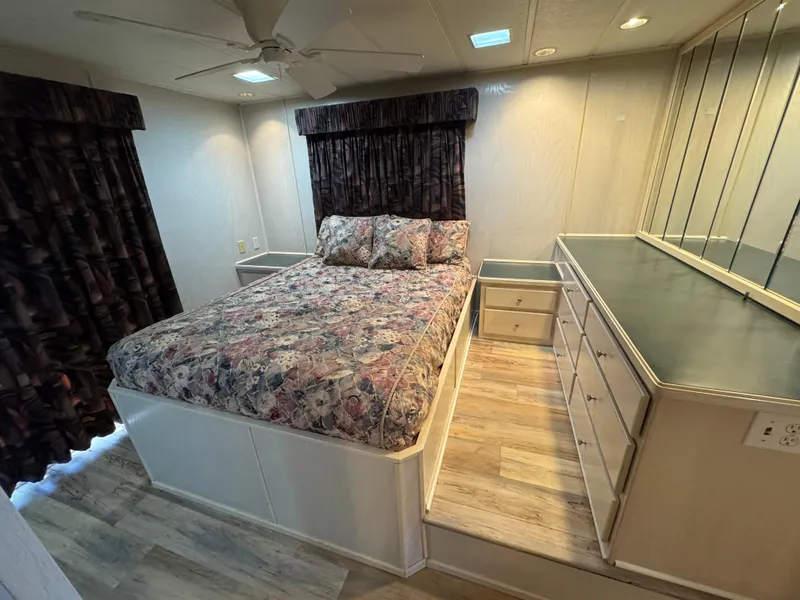 Slide: The Image of Cozy bedroom in 1996 Stardust Cruisers 72x16 houseboat with floral bedding and ample storage. - 42
