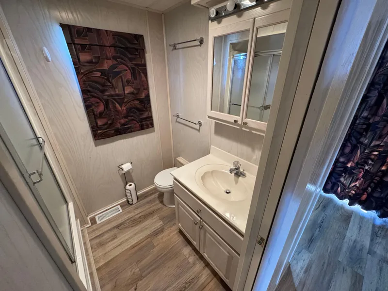 Slide: The Image of Bathroom interior of 1996 Stardust Cruisers 72x16 houseboat with modern fixtures and wood flooring. - 43