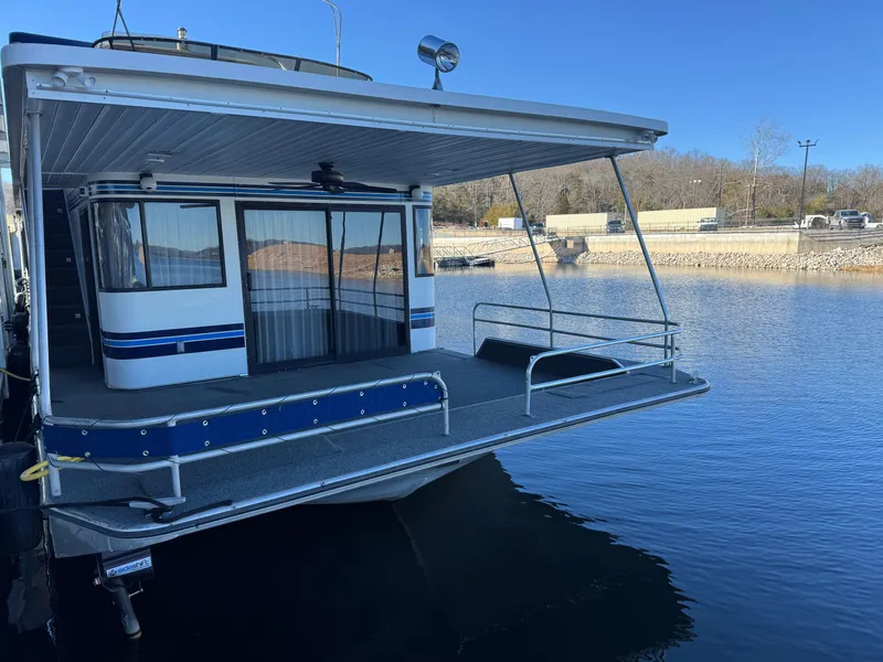 Slide: The Image of 1996 Stardust Cruisers 72x16 houseboat docked on a calm lake. - 5