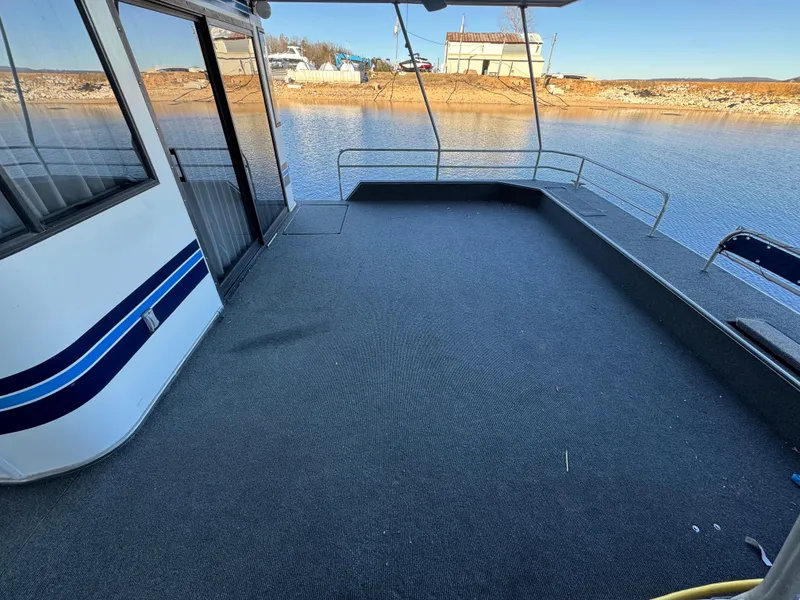 Slide: The Image of 1996 Stardust Cruisers 72x16 houseboat deck with water view and railing. - 6
