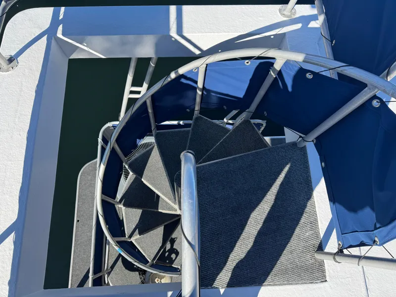 Slide: The Image of Spiral staircase on 1996 Stardust Cruisers 72x16 houseboat, featuring blue accents and metal railing. - 8