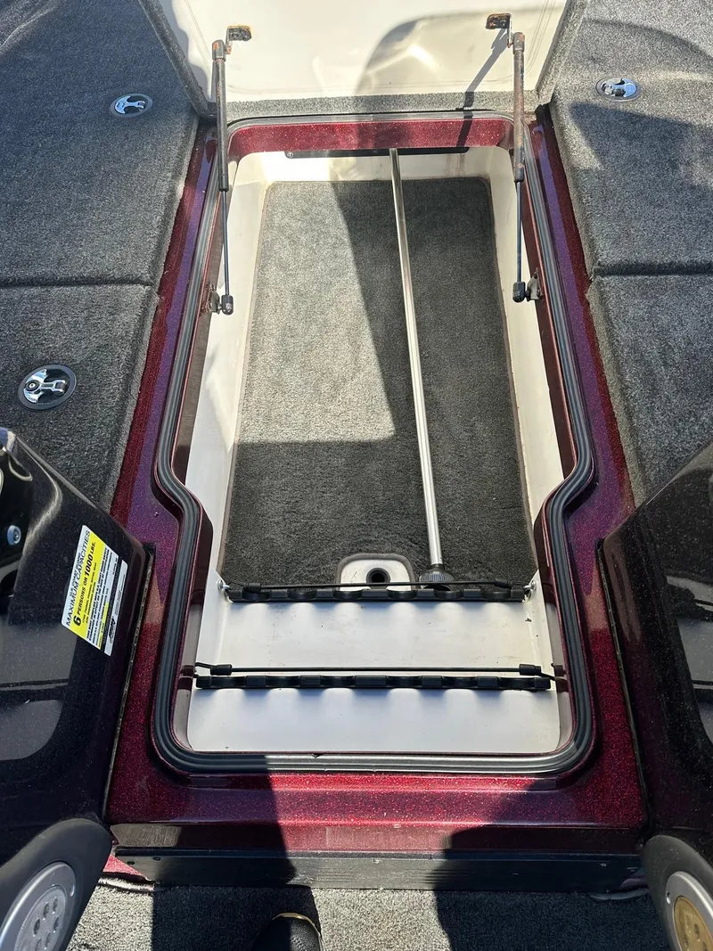 Slide: The Image of Open storage compartment in a 2012 Ranger 619VS boat, featuring carpeted interior. - 17