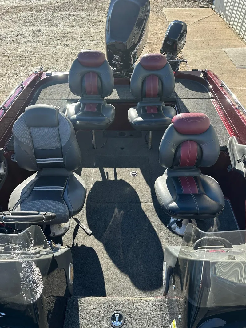 Slide: The Image of 2012 Ranger 619VS boat interior with four seats and motor, parked on concrete. - 22