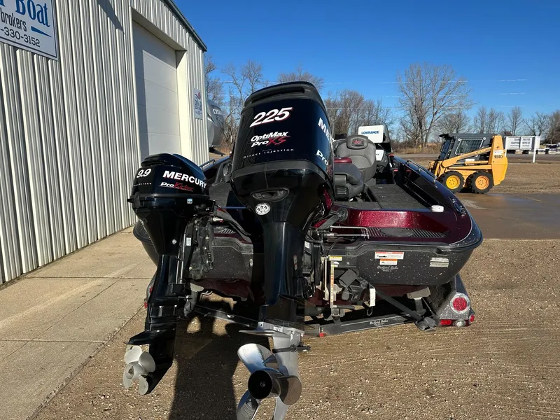 Slide: The Image of 2012 Ranger 619VS boat with dual Mercury outboard motors, parked outside a building. - 23