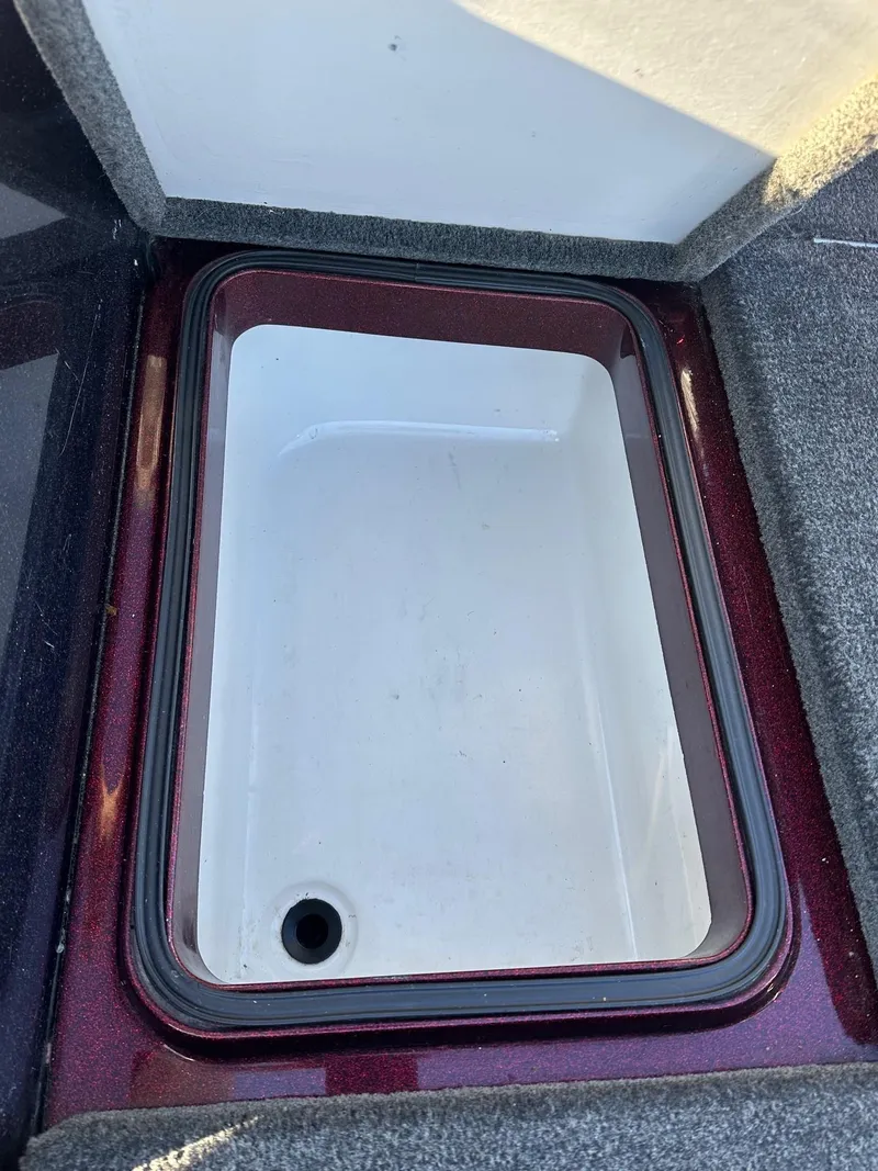 Slide: The Image of 2012 Ranger 619VS boat storage compartment with drain, featuring carpeted edges. - 38