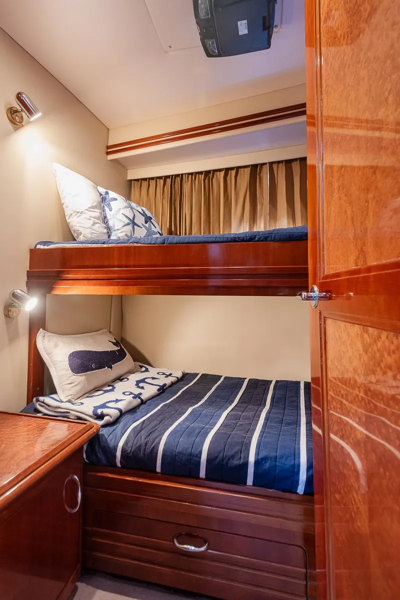 Slide: The Image of Luxurious 2005 Carver 560 Voyager yacht cabin with cozy bunk beds and elegant wood finish. - 44