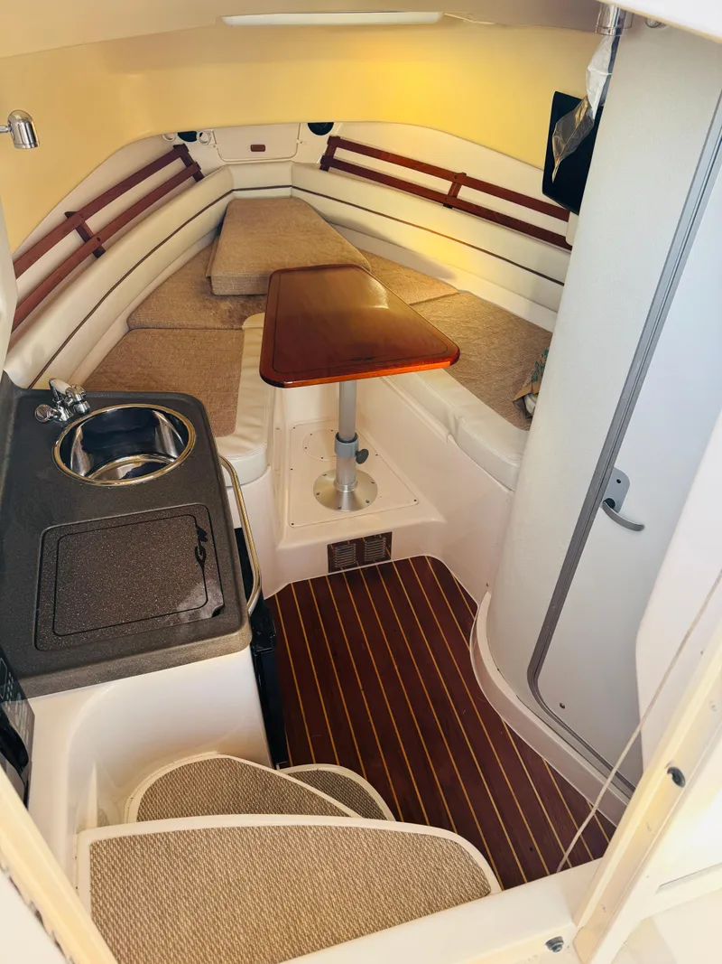 Slide: The Image of 2005 Grady-White Marlin 300 cabin interior with seating, table, and kitchenette. - 10