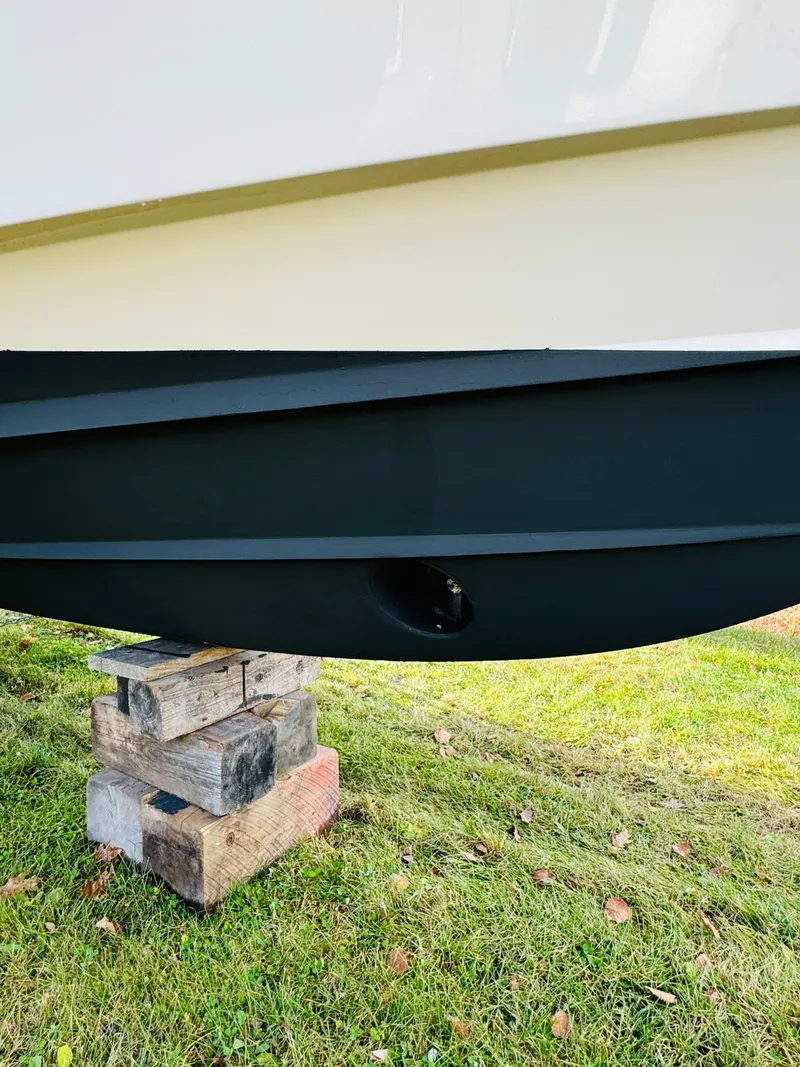 Slide: The Image of 2005 Grady-White Marlin 300 boat hull on wooden blocks, grassy background. - 18