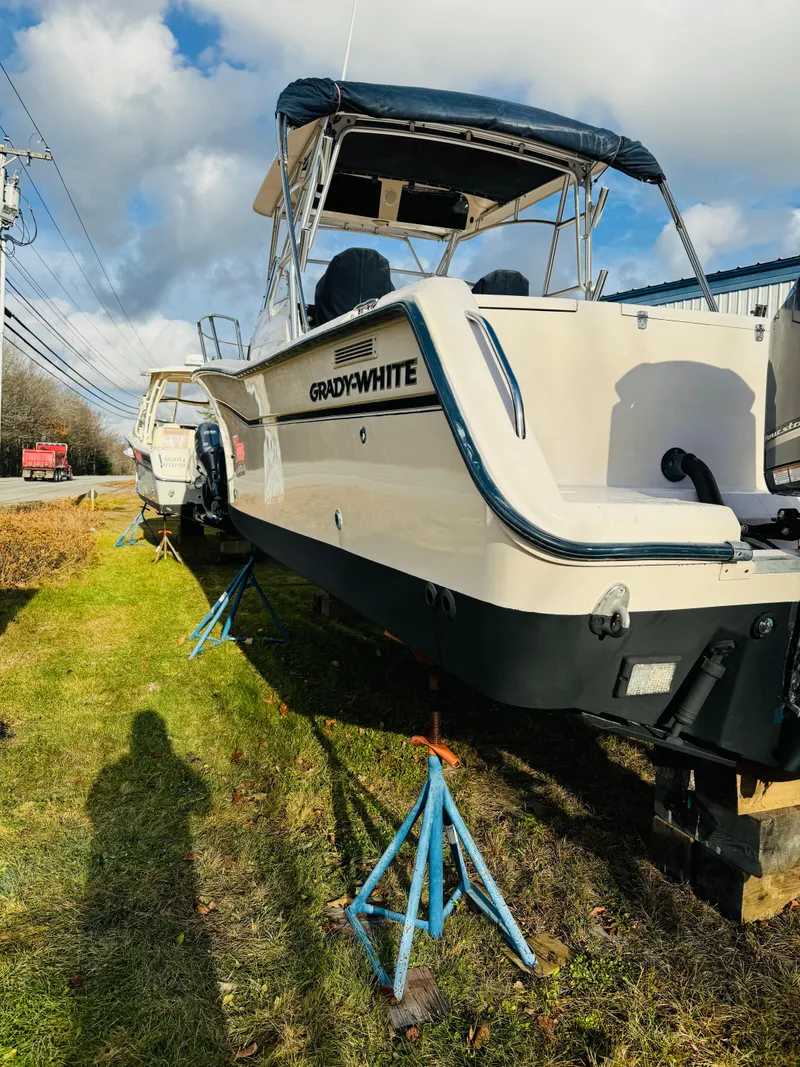 Slide: The Image of 2005 Grady-White Marlin 300 boat on stands, grassy area, partly cloudy sky. - 19