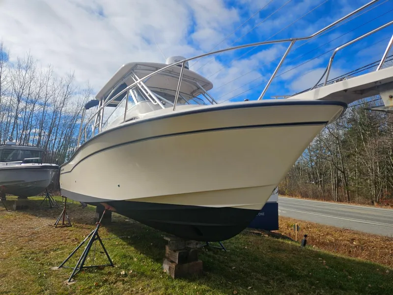 Slide: The Image of 2005 Grady-White Marlin 300 boat on stands, outdoors, under a partly cloudy sky. - 2
