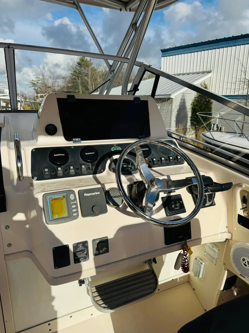 Slide: The Image of 2005 Grady-White Marlin 300 boat dashboard with steering wheel and navigation controls. - 5