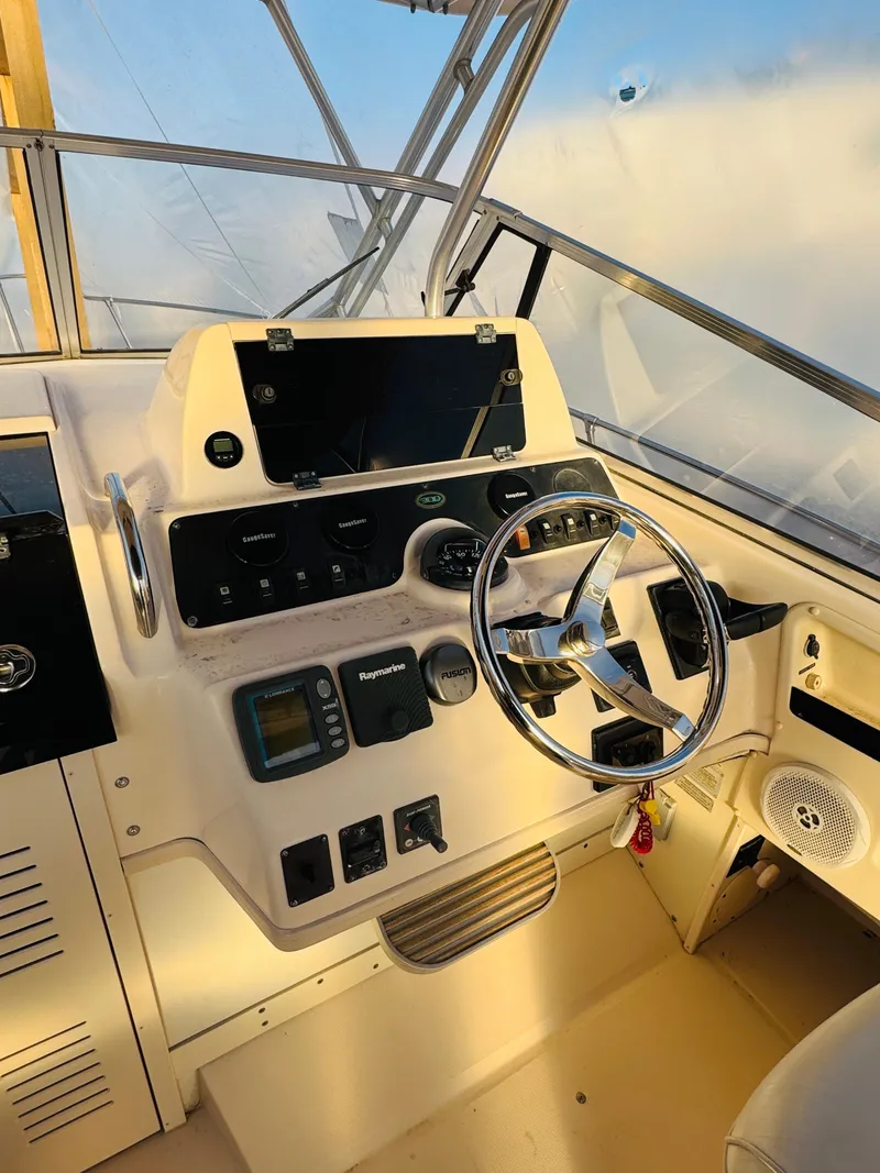 Slide: The Image of 2005 Grady-White Marlin 300 boat helm with steering wheel and navigation controls. - 6