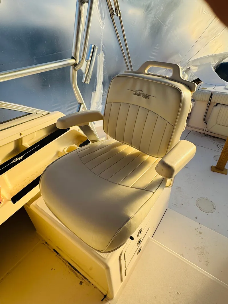 Slide: The Image of Captain's chair on 2005 Grady-White Marlin 300 boat, featuring beige upholstery and armrests. - 8