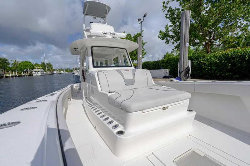 Slide: The Image of 2023 SeaVee 420Z boat with sleek design and spacious deck, docked by the water. - 11