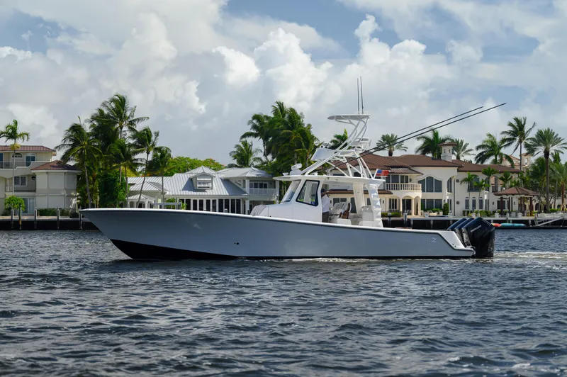 Slide: The Image of 2023 SeaVee 420Z boat cruising on a scenic waterway with palm trees and houses. - 29