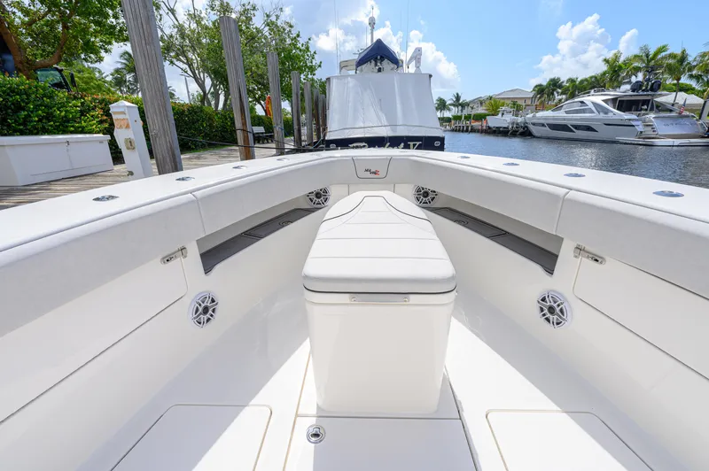 Slide: The Image of 2023 SeaVee 420Z boat interior with seating, docked by a marina. - 6