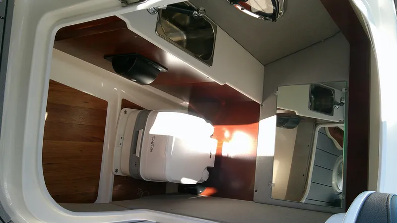 Slide: The Image of Interior of 2025 Chaparral 28 Surf boat with compact bathroom amenities. - 11