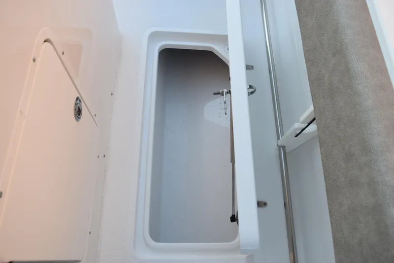 Slide: The Image of 2025 Sea Hunt Gamefish 28 storage compartment with open lid, showcasing interior space. - 17