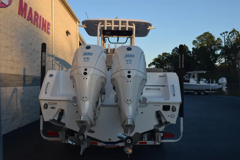 Slide: The Image of 2025 Sea Hunt Gamefish 28 with twin 300 HP engines, rear view at a marine dealership. - 4