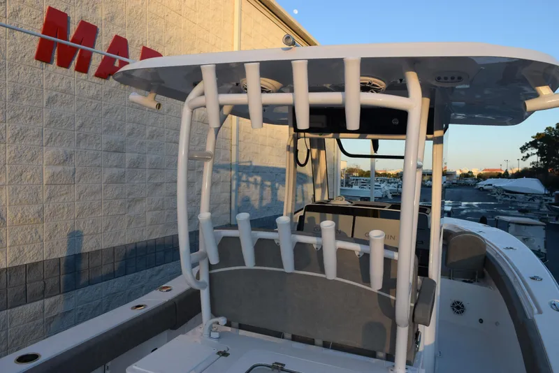 Slide: The Image of 2025 Sea Hunt Gamefish 28 boat with rod holders and T-top, docked near a marina. - 6
