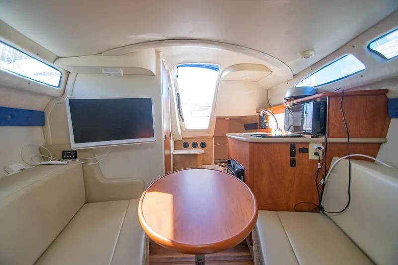 Slide: The Image of Interior of 2010 Bayliner 2450 Ciera boat with seating, table, and kitchenette. - 11