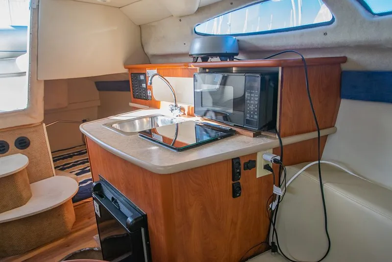 Slide: The Image of Interior of 2010 Bayliner 2450 Ciera boat with kitchenette, sink, and microwave. - 12