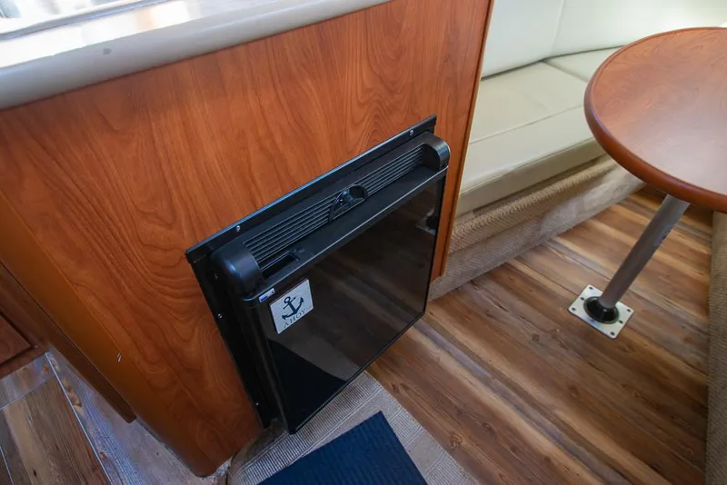 Slide: The Image of Interior of 2010 Bayliner 2450 Ciera boat with compact fridge and seating area. - 18
