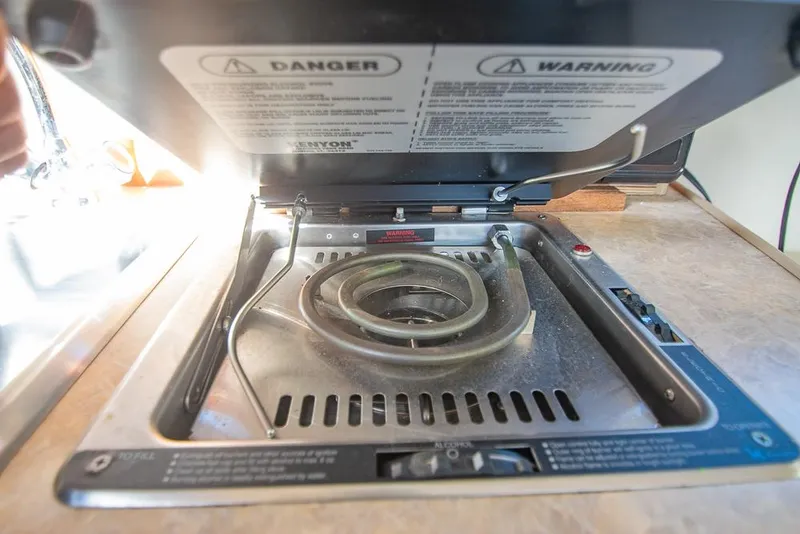 Slide: The Image of Stovetop on 2010 Bayliner 2450 Ciera boat, featuring safety warnings and controls. - 19