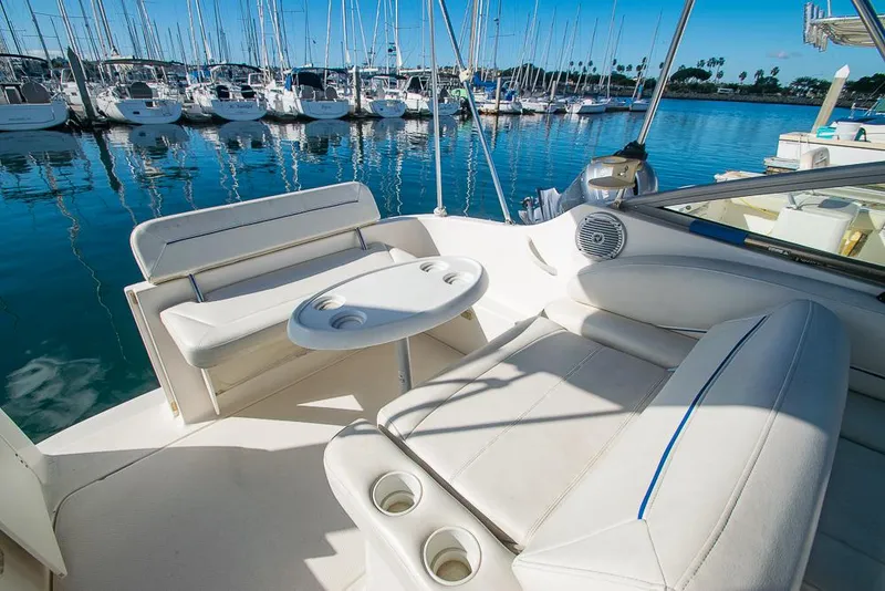 Slide: The Image of Bayliner 2450 Ciera 2010 boat interior with white seating and table, docked at marina. - 23